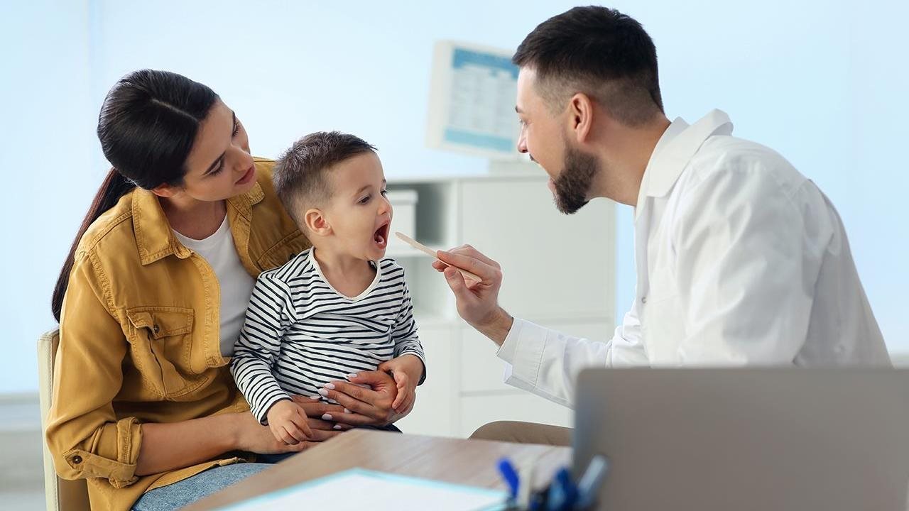 Mother and toddler son at a wellcare visit to the doctor.