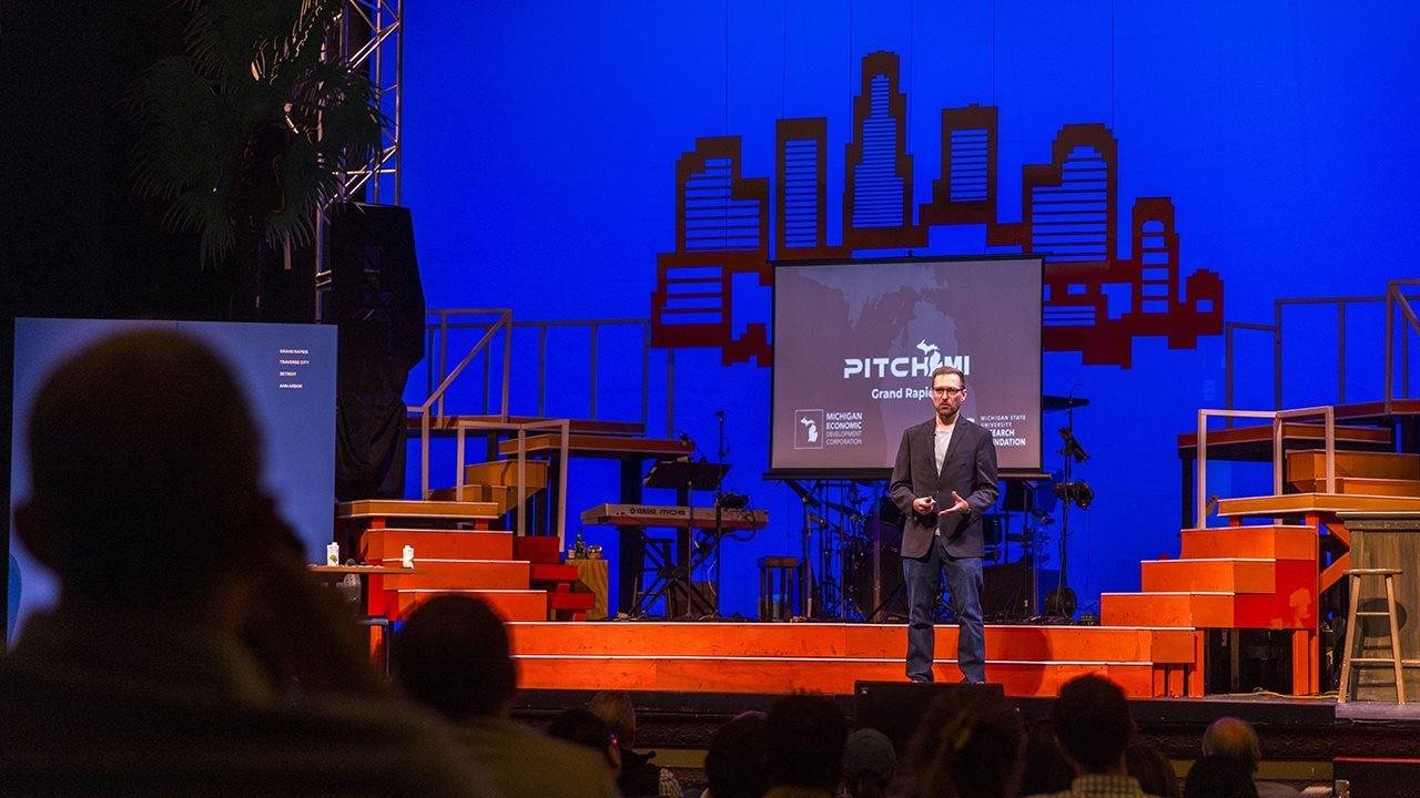 Man speaking on a stage.