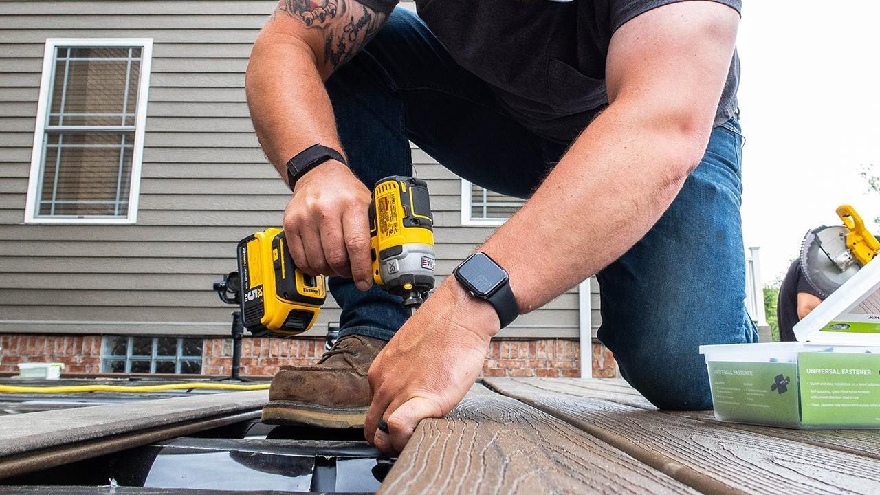 A professional works on installing a deck