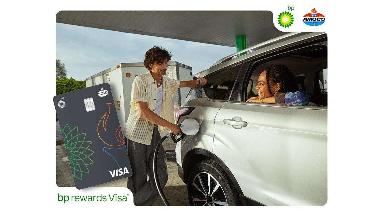 El hombre llena el auto en una gasolinera mientras la mujer lo observa desde la ventana del pasajero. La imagen muestra los logotipos de BP, Standard y Visa.
