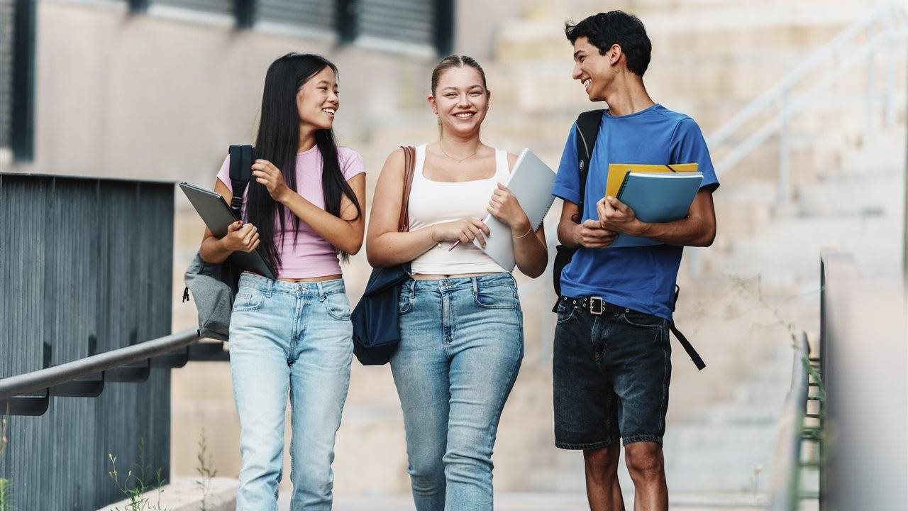 College students carry books and walk on campus. The Americas Meningitis Alliance recommends the meningococcal vaccine.