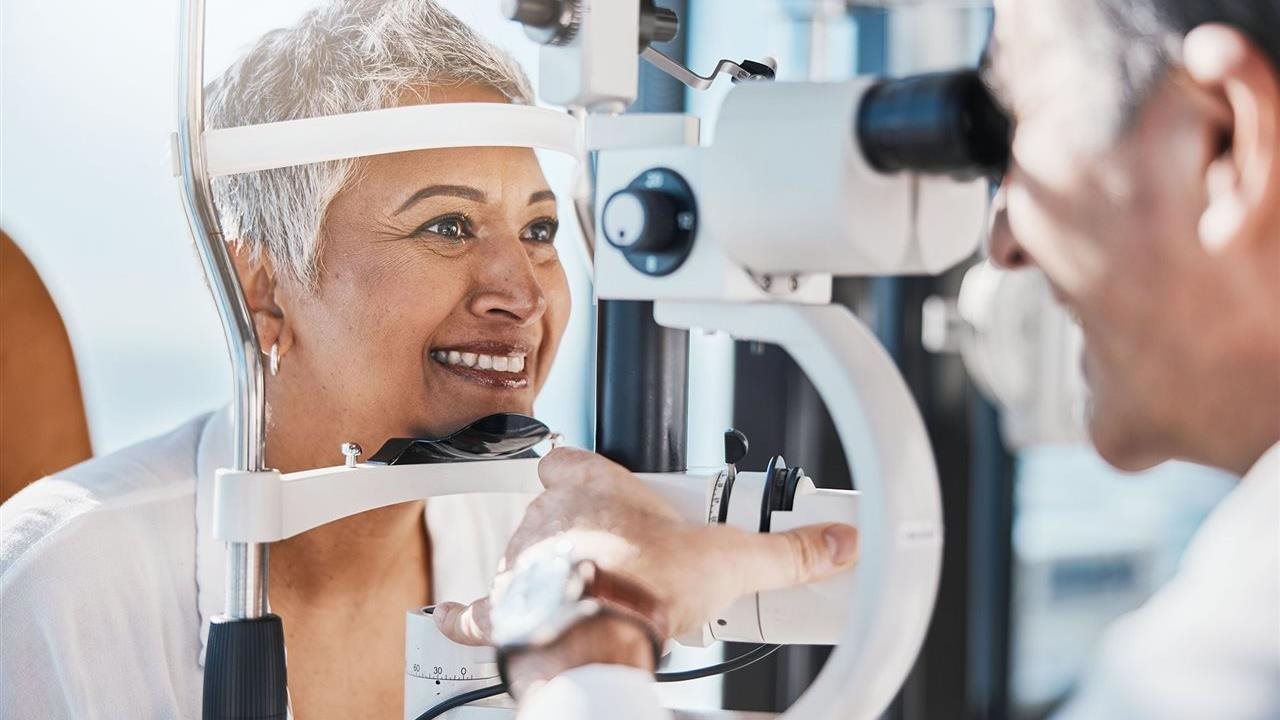 Mujer mayor sometiéndose a un examen ocular por parte de un médico.