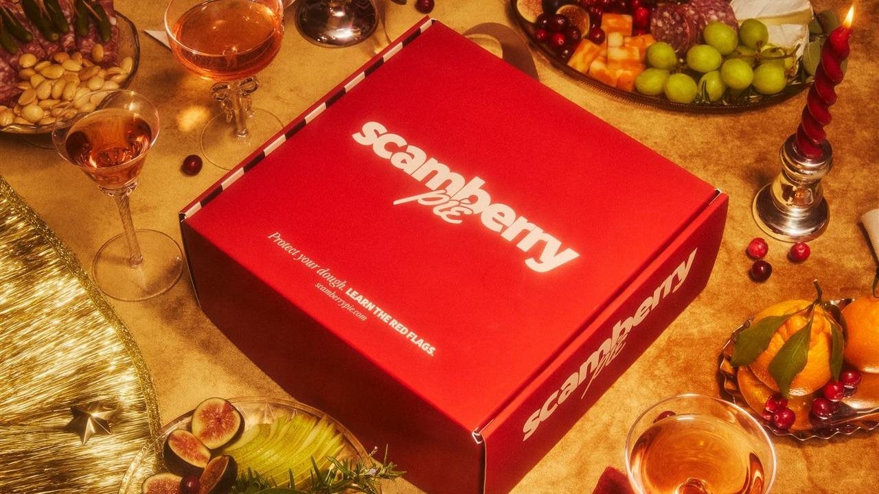 Scanberry Pie in a red box sitting on a holiday table with food and beverages.