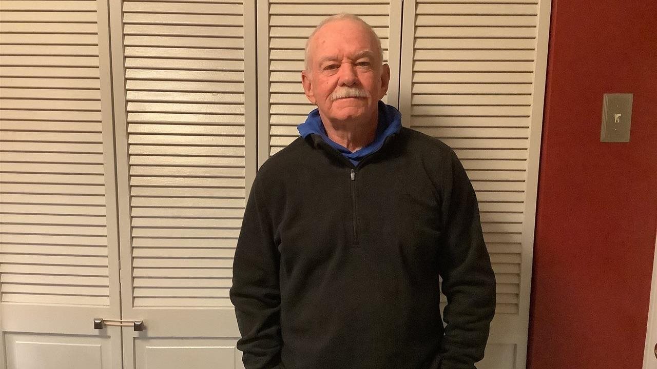 Jim Mcrea standing in a bedroom in his home.