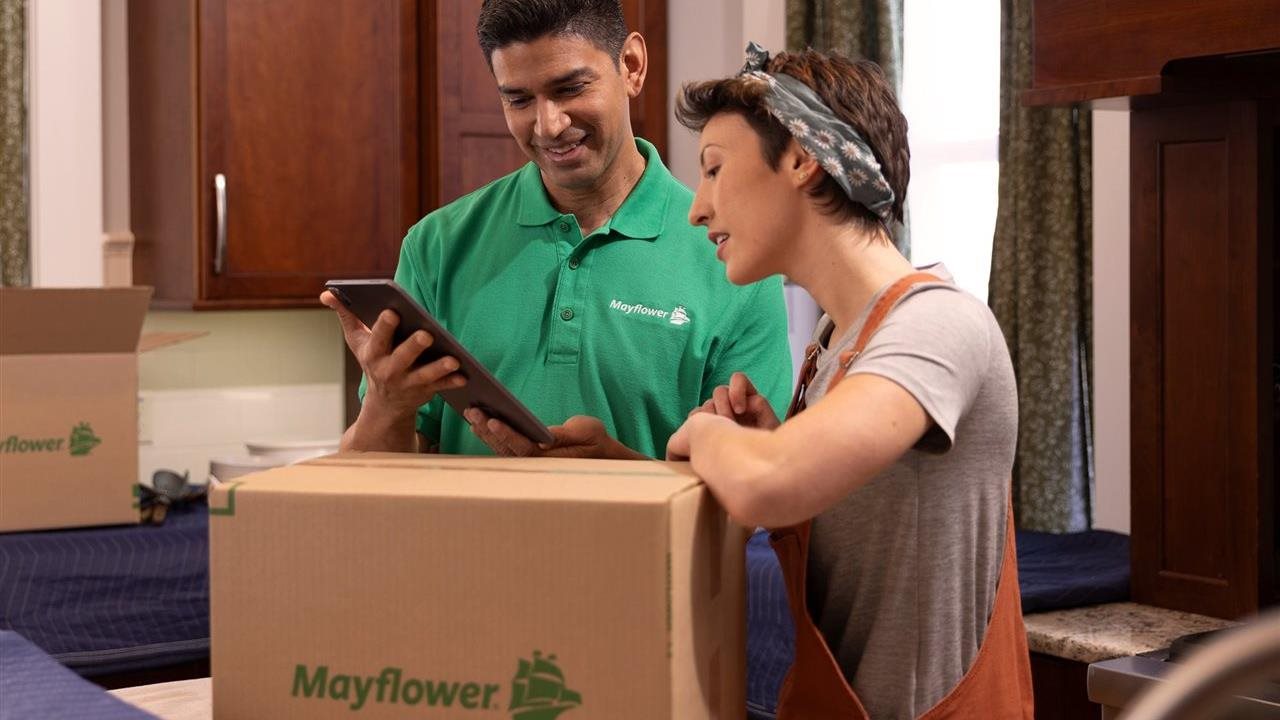 Representative from Mayflower talking with a client in the kitchen of her new home.