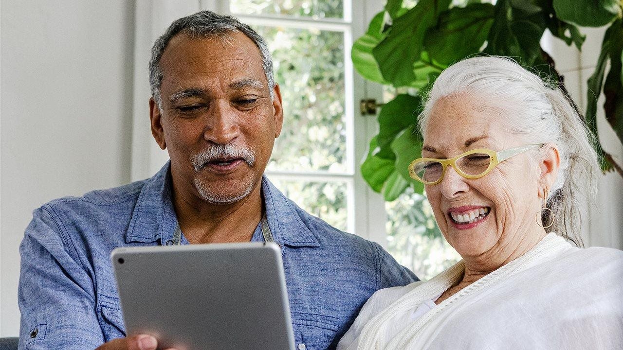Couple looking a tablet while on the couch. A D-SNP, Dual Special Needs plan, is a Medicare Advantage plan for people who have Medicare and Medicaid.