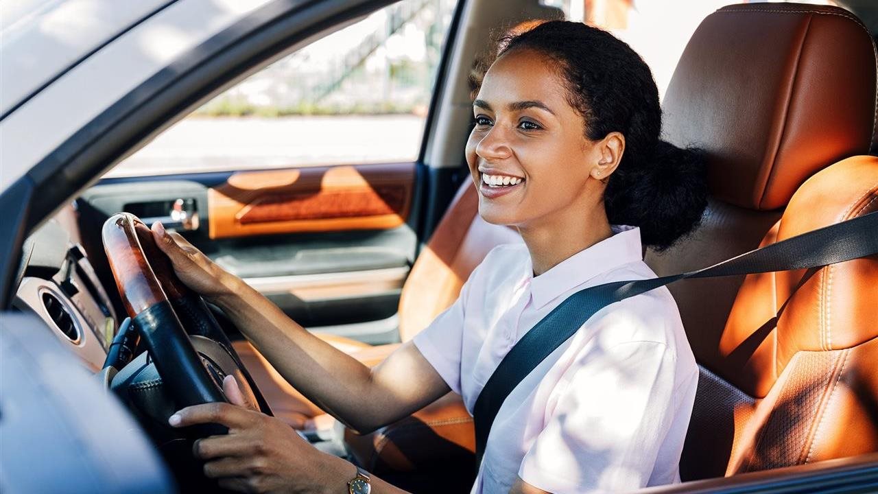 Happy woman driving car. Flexcar bundles car costs: insurance, maintenance and roadside assistance into one monthly payment.