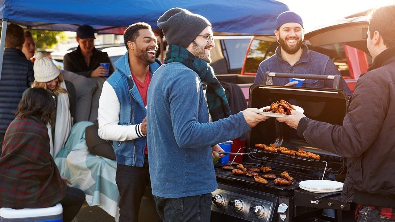 A group of friends tailgating at a football game.
