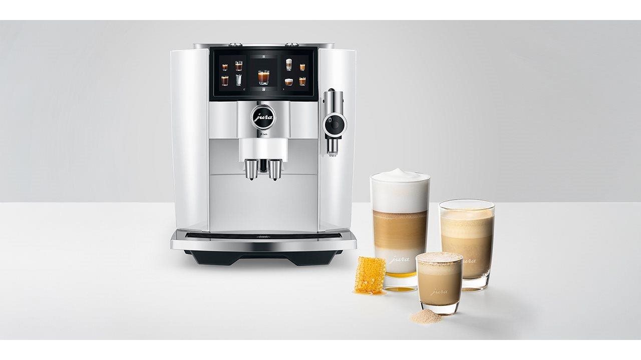 JURA, Diamond White, Sweet Foams Coffee Machine on a counter near cups of coffee.