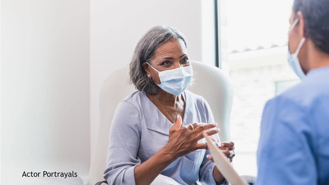 Patient and doctor wearing masks and discussing the use of a subcutaneous injection (under the skin), like OPDIVO QVANTIG™