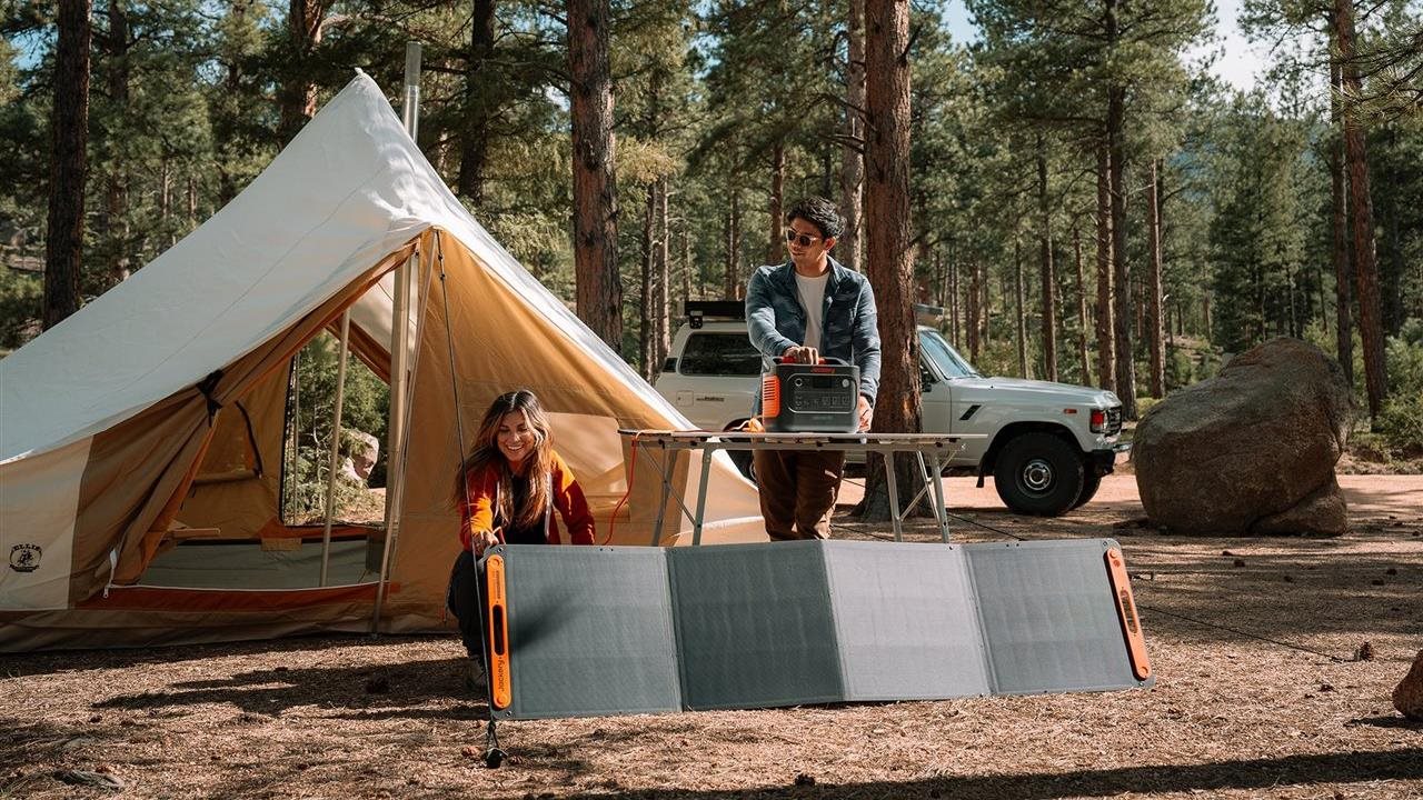 Couple setting up a tent campsite with the Jackery portable generator.