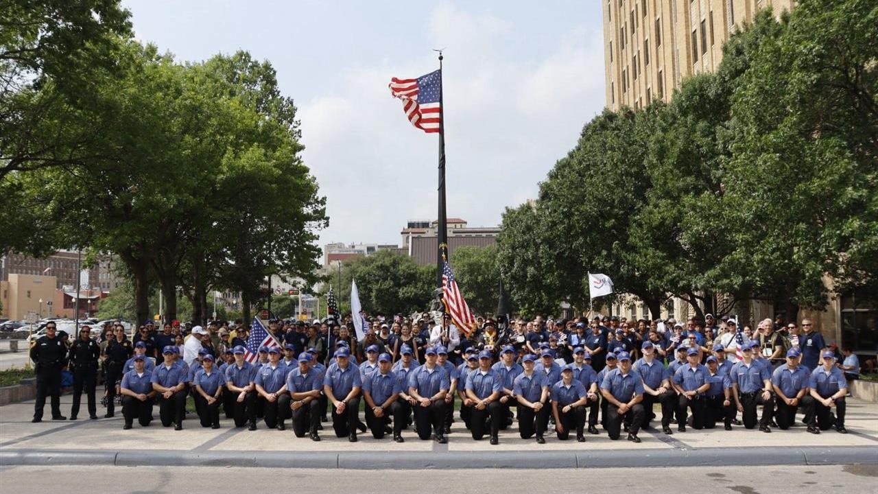 A group of first responders taking a knee on the mall. Carry The Load is a nonprofit that honors the sacrifices made by these heroes.