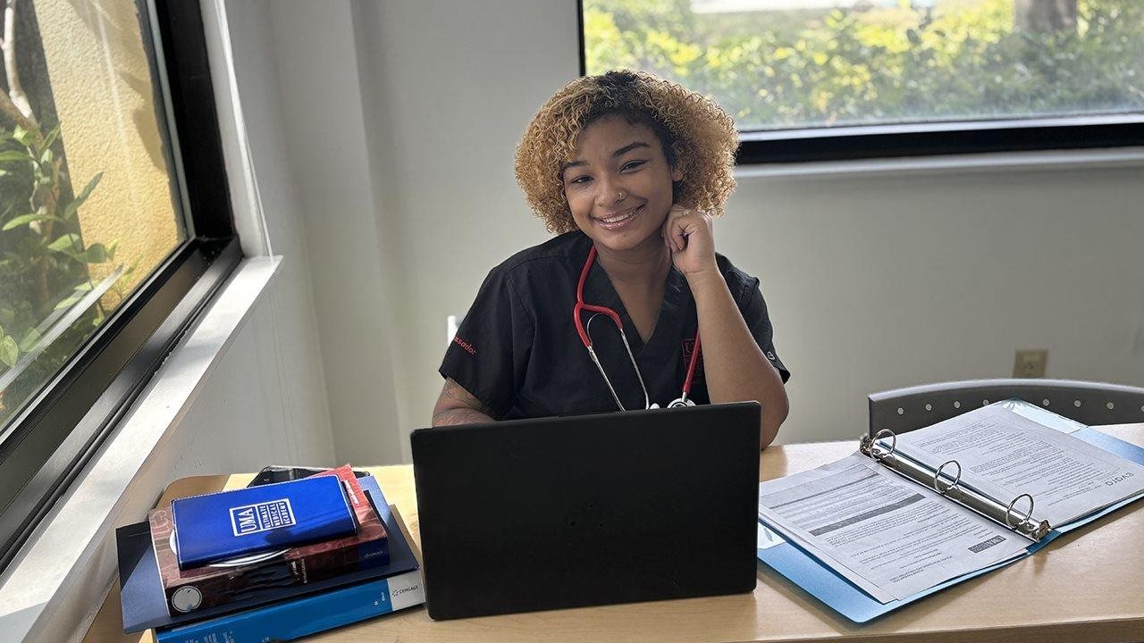 Jada, a single mom and student at the Ultimate Heath Institute, studying books and working online.