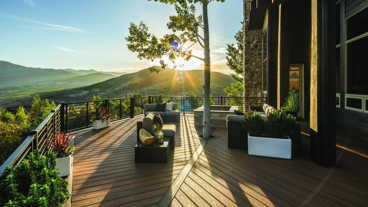 Trex deck with outdoor living room, fire feature and plenty of space to enjoy a mountain vista from the backyard of modern style home.