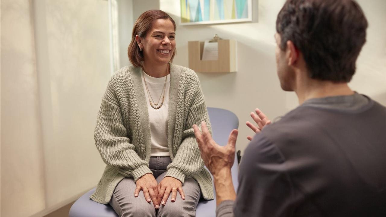 Woman talking with doctor in her office.