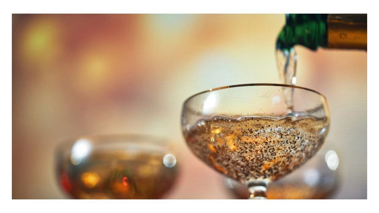 Bottle pouring bubbly drink in to a glass.