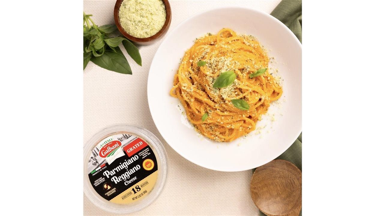 Plate of pasta with a container of Galbani Parmigiano Reggiano grated cheese.