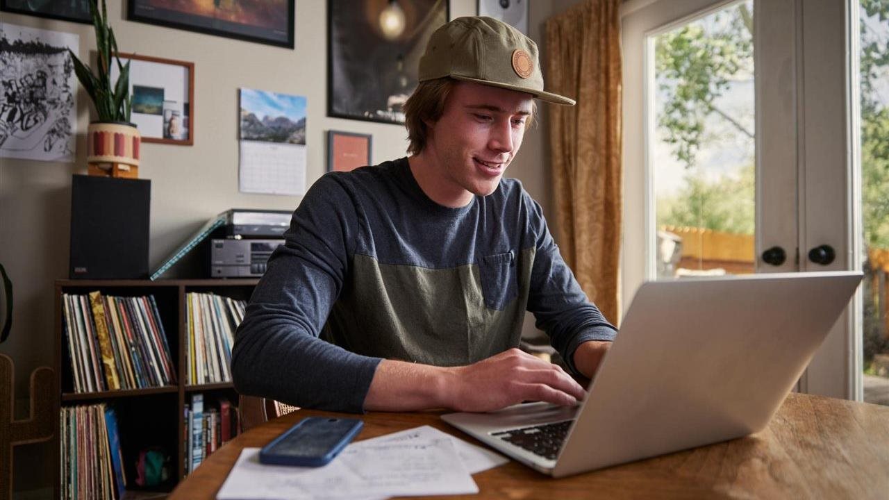 Man working on his laptop at home. Intuit's AI, that powers TurboTax, is purpose-built and trained by tax experts.