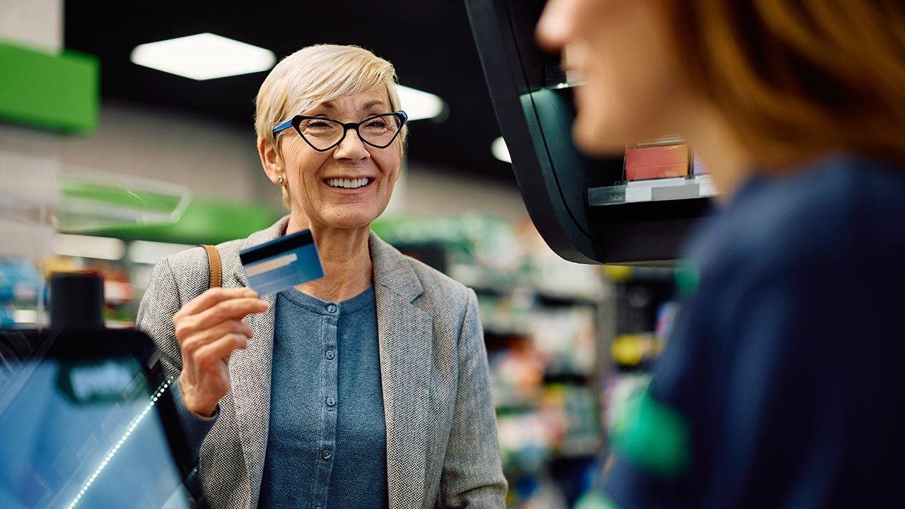 Senior woman purchasing OTC products at a Drug store.