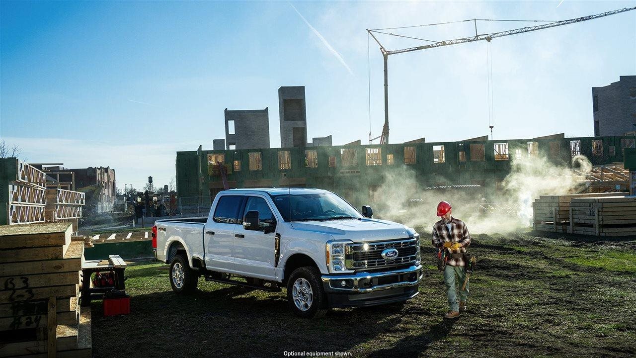 Man wearing hard hat working on construction site with his Ford Truck.