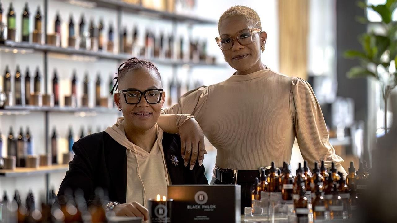 Tasha and Rica Kendrick-Palmer pose together with their scent formulas in glass jars.