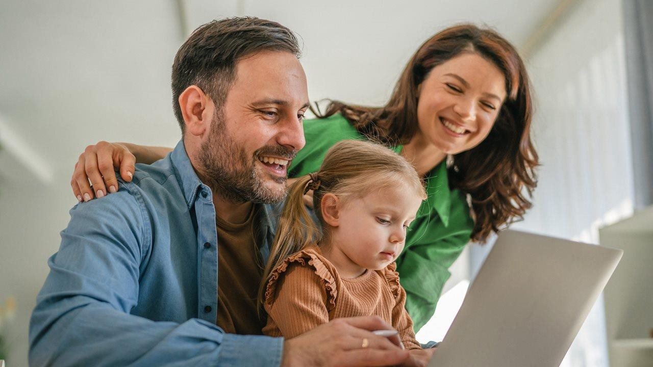 Mom, dad and little girl using a laptop at home. Ziply Fiber has designed a simple process to switch ISPs.