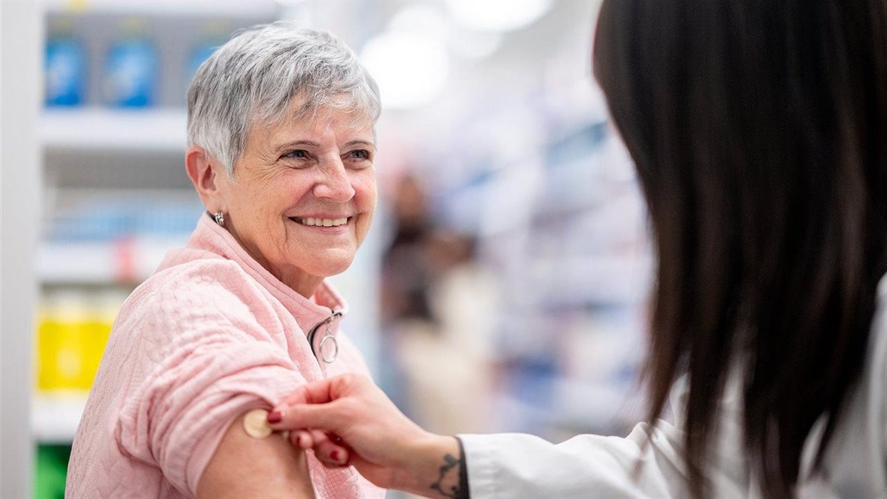 Mujer recibiendo una vacuna en una farmacia. Walgreens alienta a las personas mayores a vacunarse contra la culebrilla.