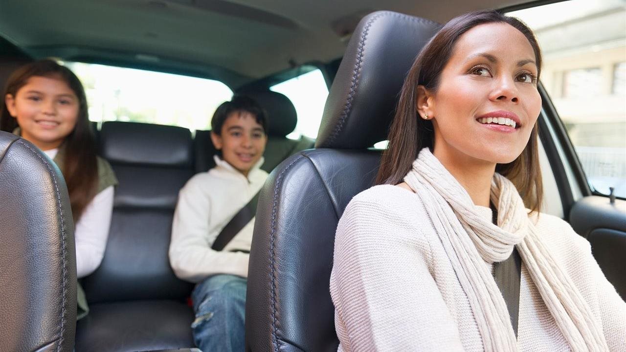 Mom driving car with two kids in backseat. It's easy to check for vehicle safety recalls at CheckToProtect.org.