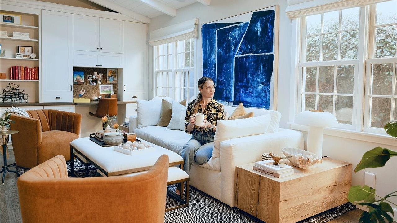 Sabrina cozy on the couch in her livingroom with a cup of coffee