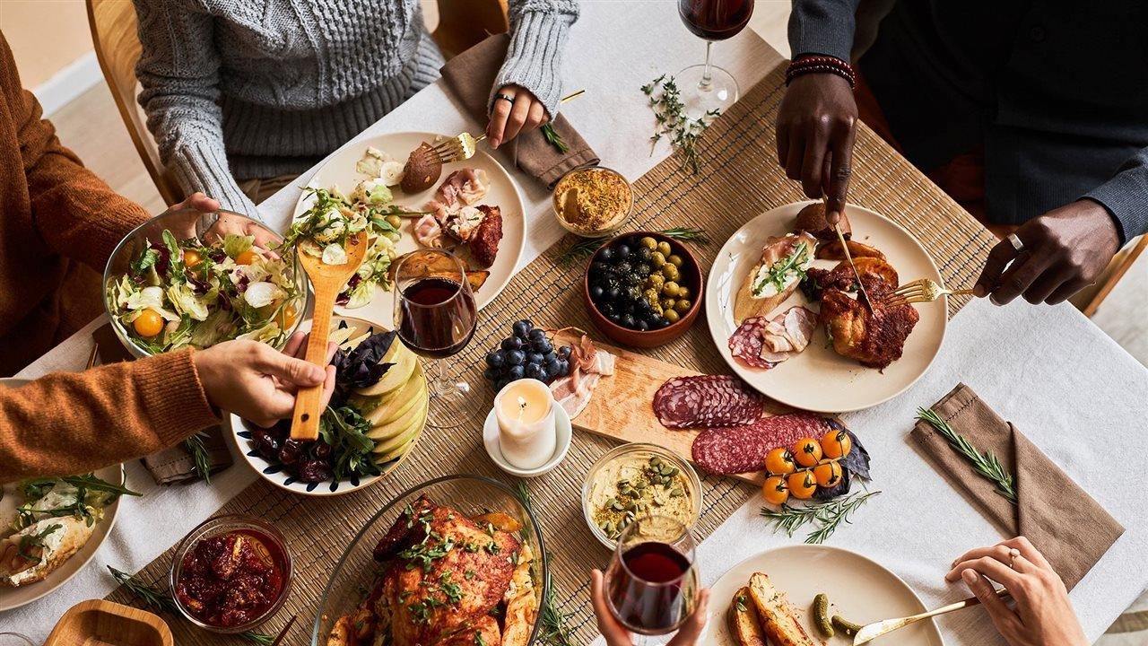 Diverse group of friends enjoying homemade food during the holidays which can sometimes lead to GERD-related heartburn.