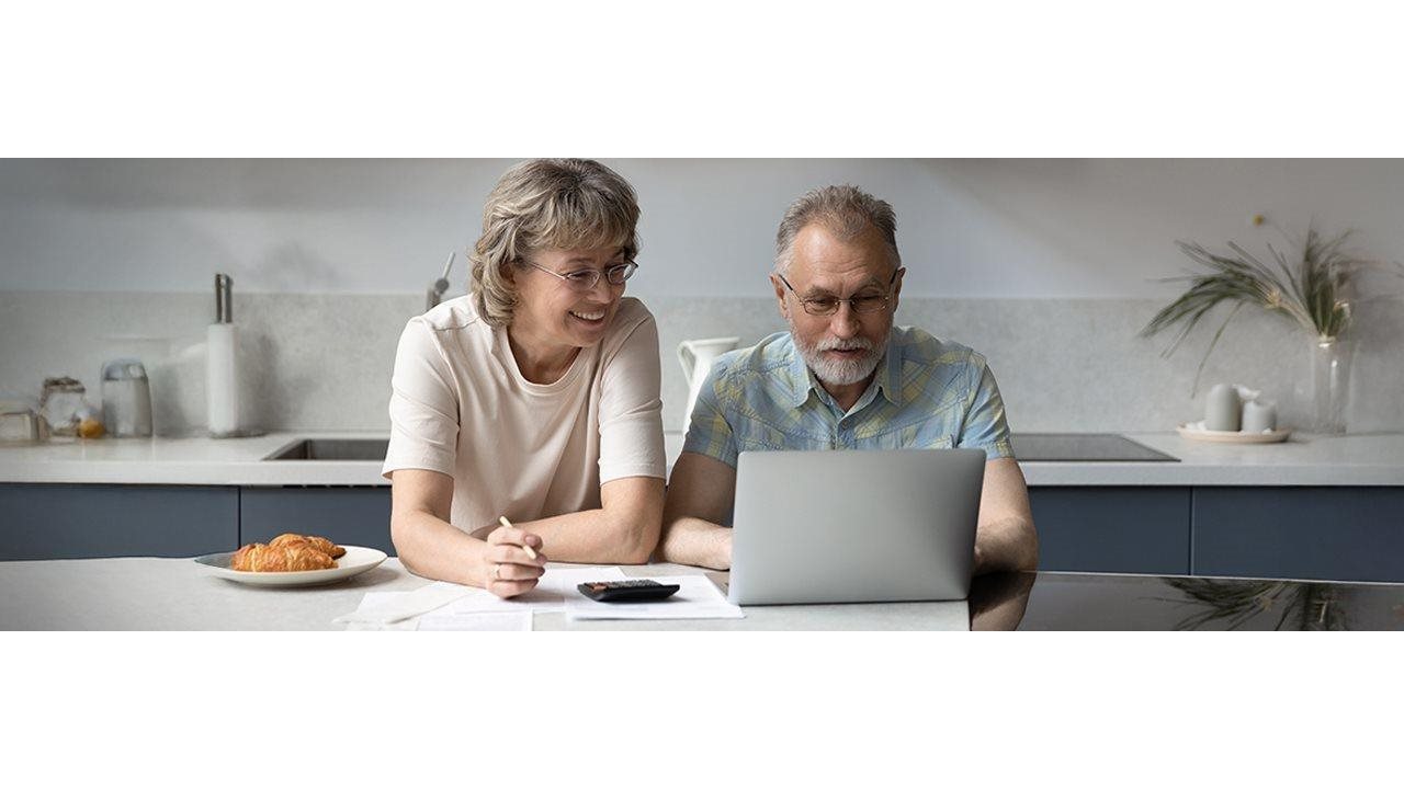 Older couple working on budget on a laptop.
