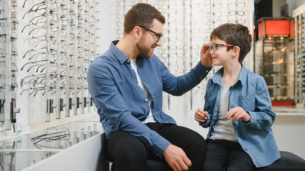 Dad and son pick out glasses. Visit www.AffordableVisionCare.org/Research for the "Keeping Vision Care Within Reach" report.