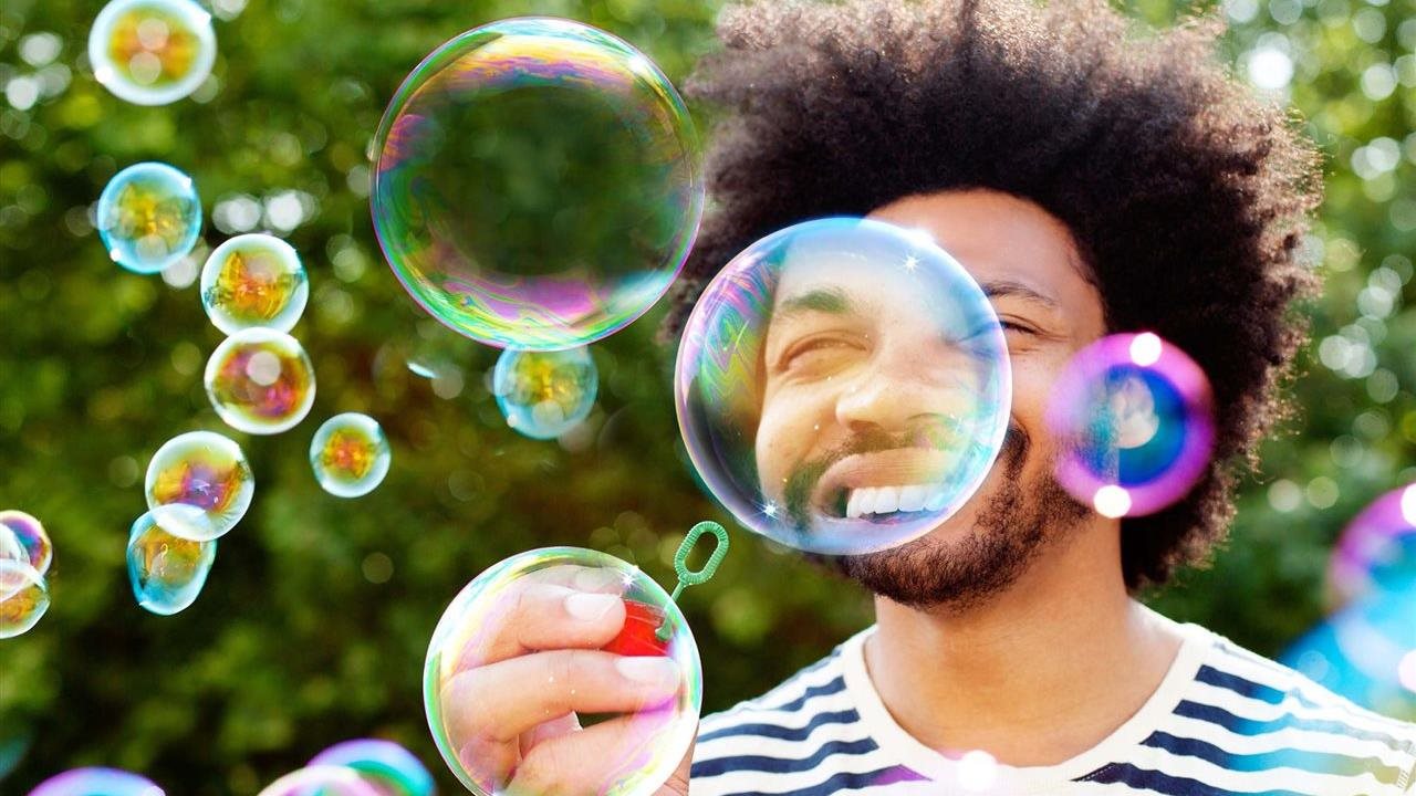Man blowing bubbles that float in front of his face. Hereditary angioedema, or HAE, is a rare condition that results in unpredictable swelling attacks.