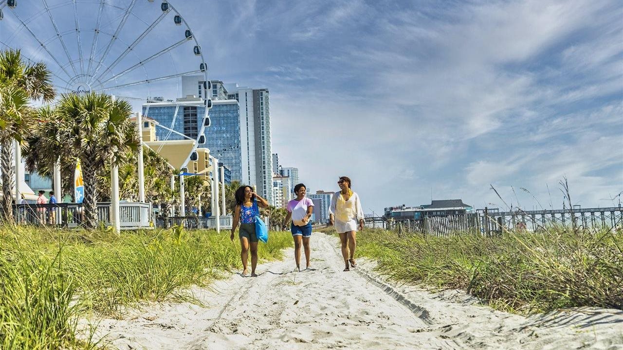 Three people walking on the sands of Myrtle Beach.