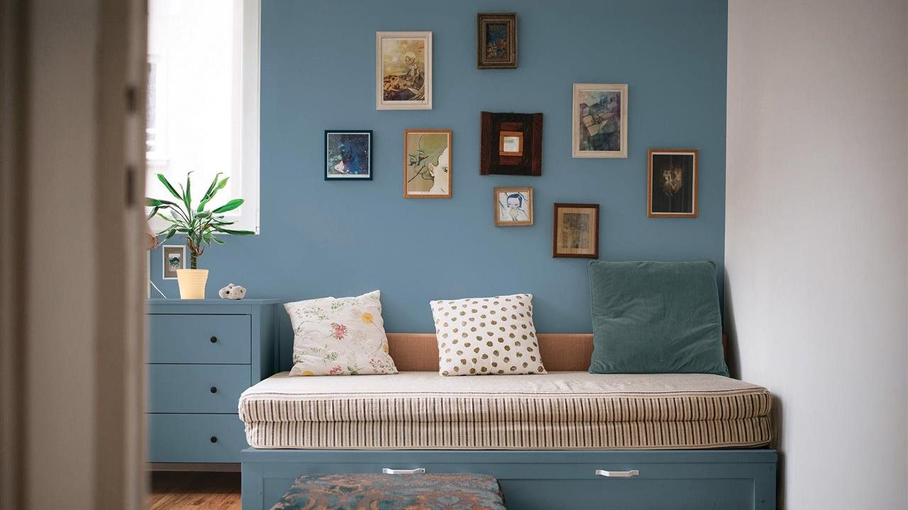 Daybed in a blue bedroom with a picture wall. Update any room with Pittsburgh Paints & Stains®.