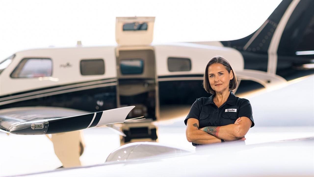 Woman standing outside a small plane. The CareerSource Florida network works through 21 local workforce development boards.