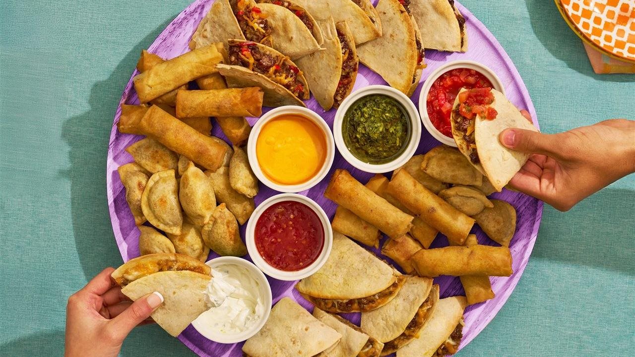 People dipping MadGenius Snacks in a variety of dipping sauces from a tray at a mashup party.