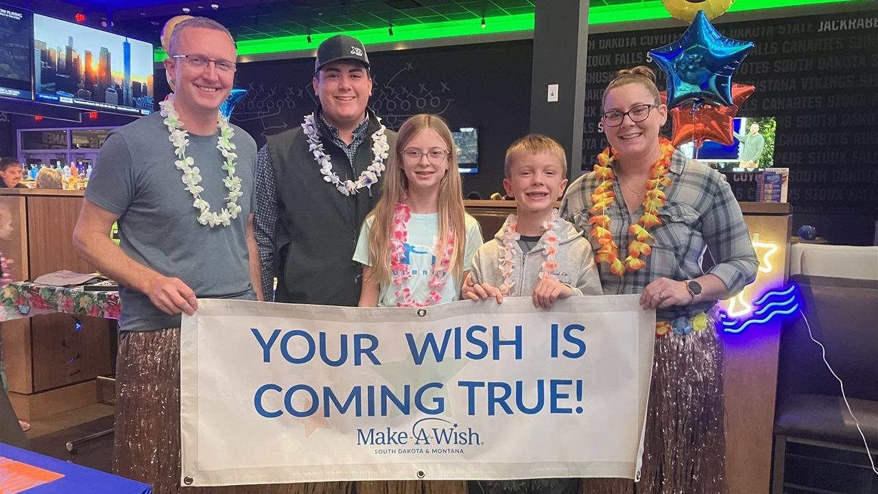 Make-A-Wish Foundation of America winning family dressed in hula skirts and lea’s celebrating at Dave & Buster's.