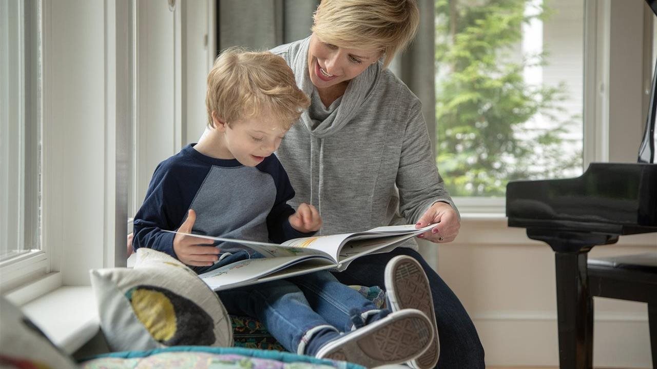 Mom and son reading a book together, balancing work and family time as advised by Bright Horizon Family Solutions.