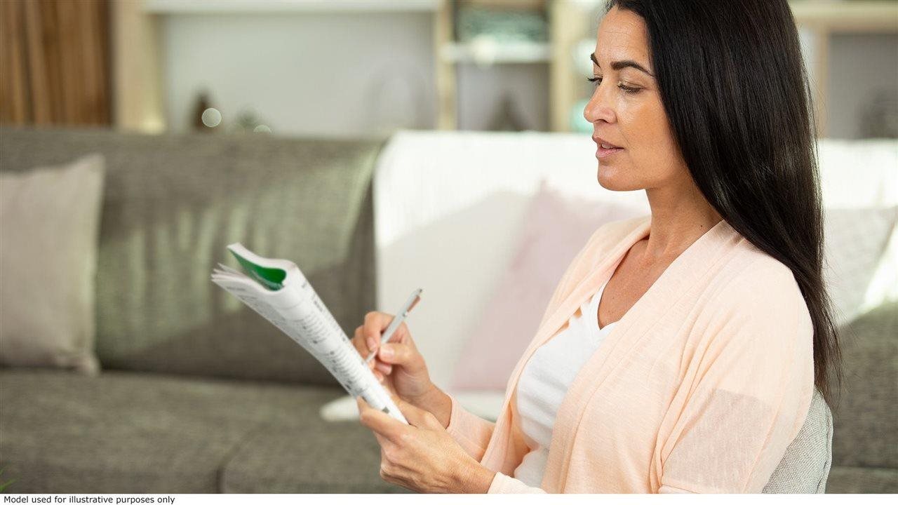 Woman on couch works a crossword puzzle. Doctor's Best Creatine Powder is third-party-tested creatine monohydrate.