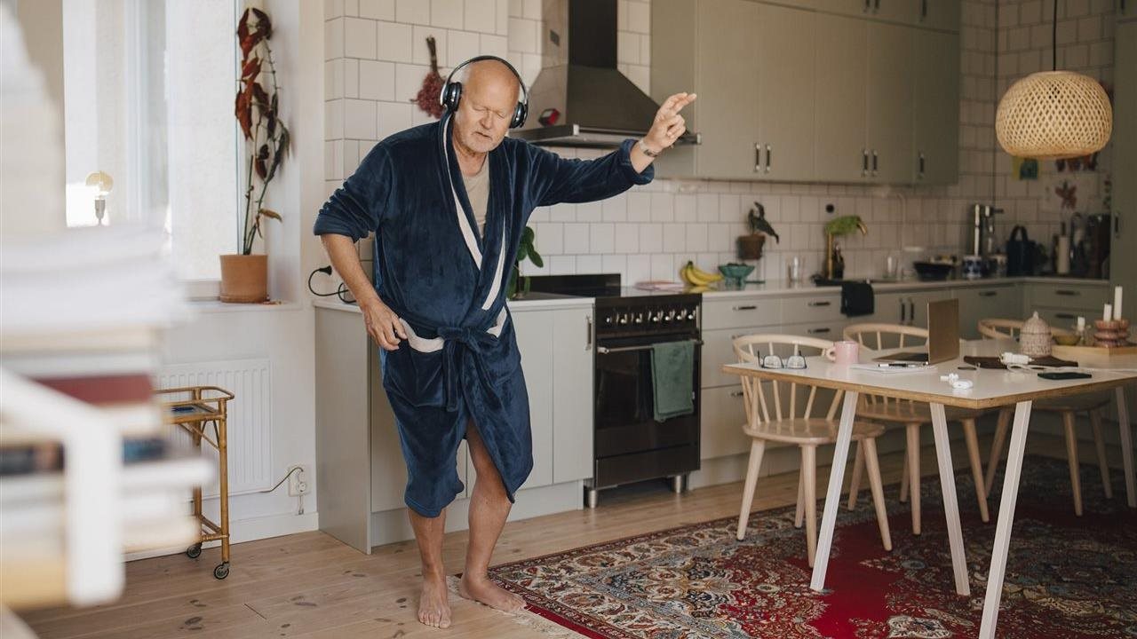 Senior man dancing in bathrobe. Members have access to savings on hearing aids and hearing care with AARP®