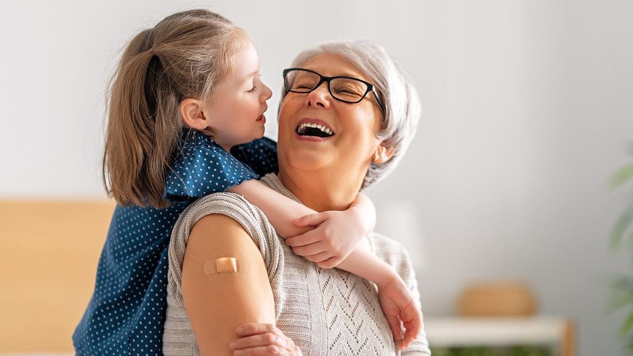 Granddaughter hugging her Grandma who just got her flu shot.